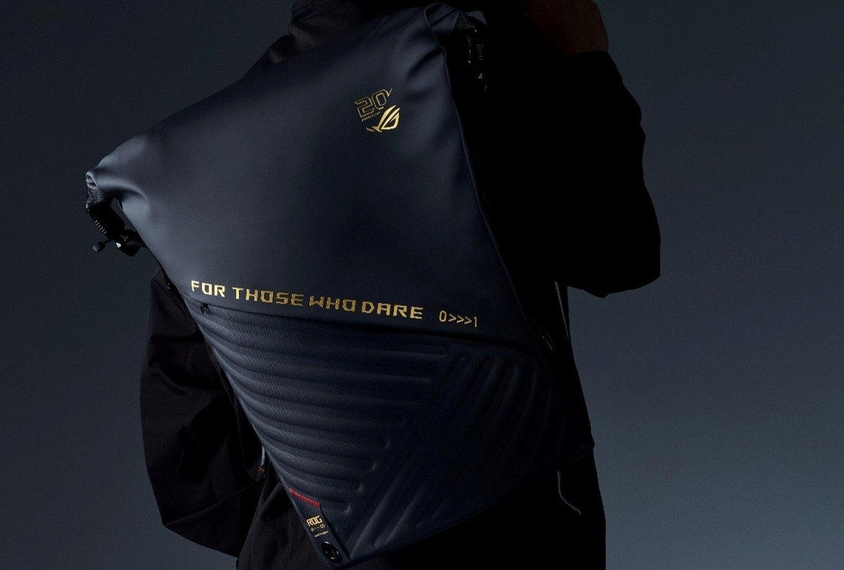 Person wearing the black ROG Slash Backpack Edition 20, which carries a gold 20th anniversary emblem and gold FOR THOSE WHO DARE lettering